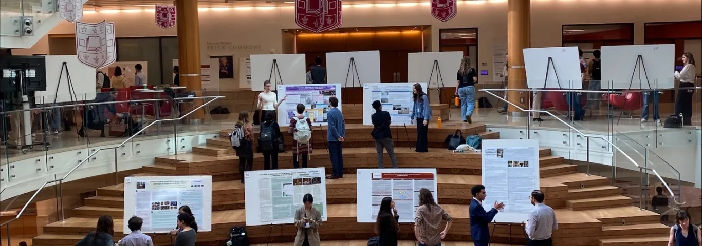 Students standing looking at posters at symposium