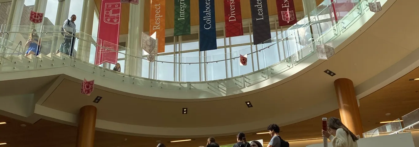 An image of Bauer Hall with students presenting posters in the background